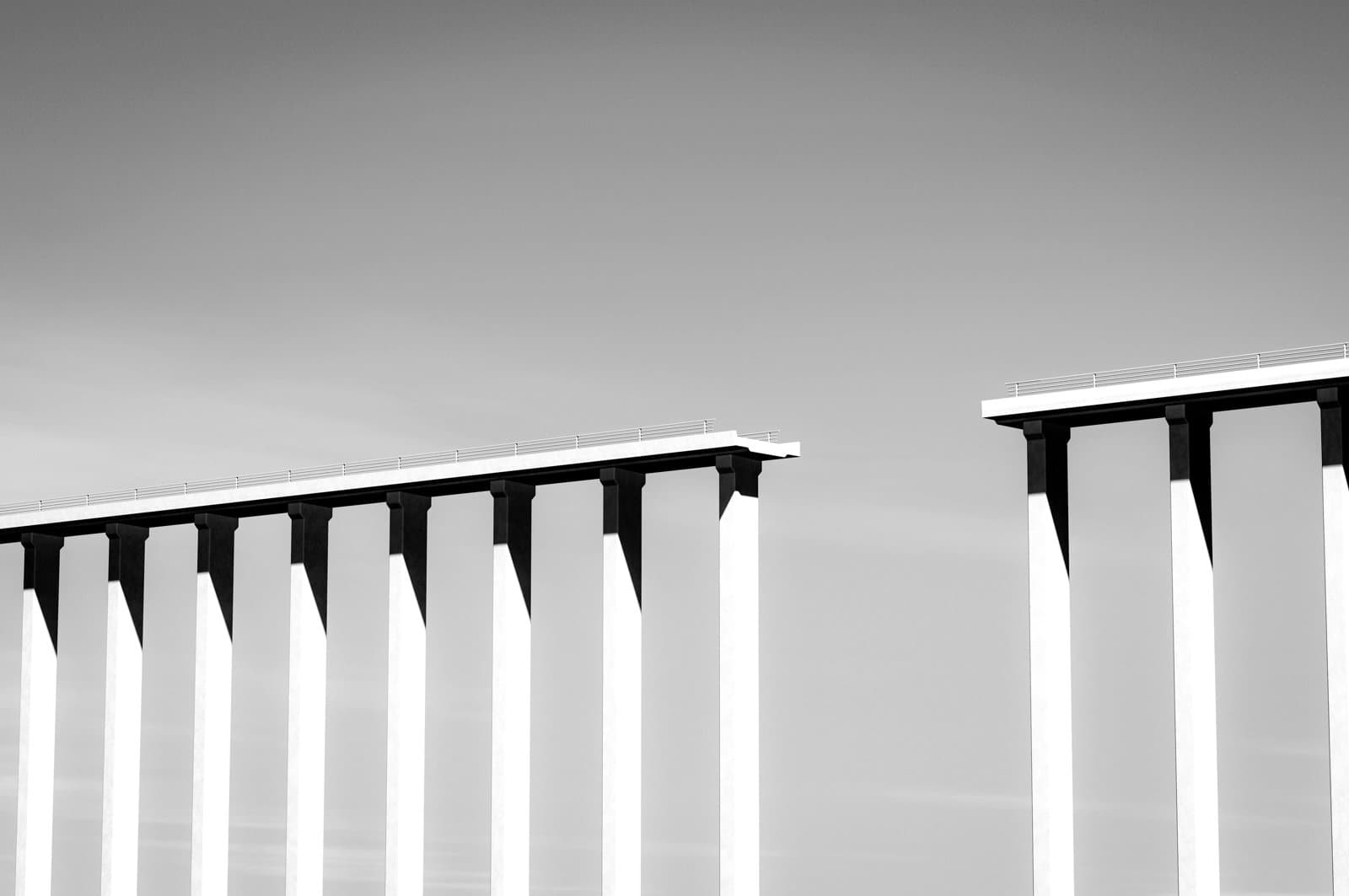 Two elevated bridge sections separated by a gap, supported by tall concrete pillars