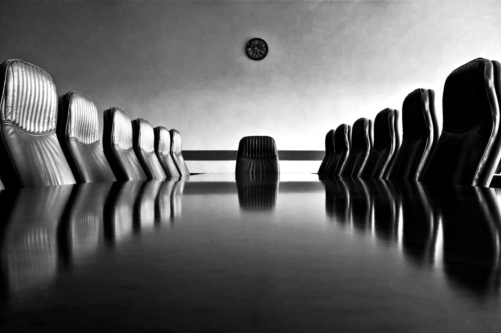 Meeting room with a big polished table and arm-chairs