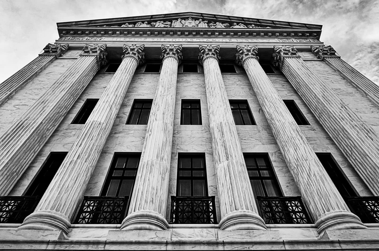 upward view of a court building with tall classical columns and detailed stonework.