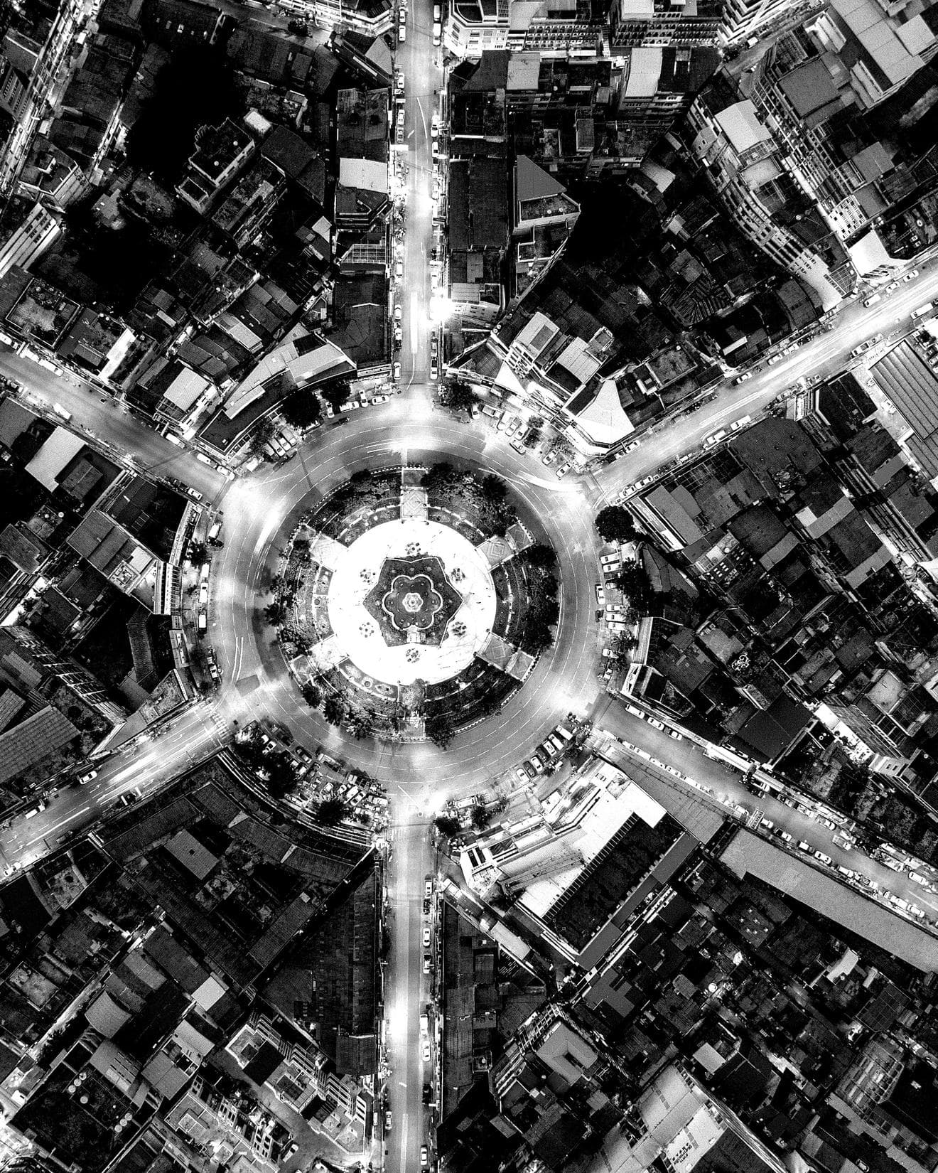 Night time aerial view of six roads meeting at a central point in Thailand